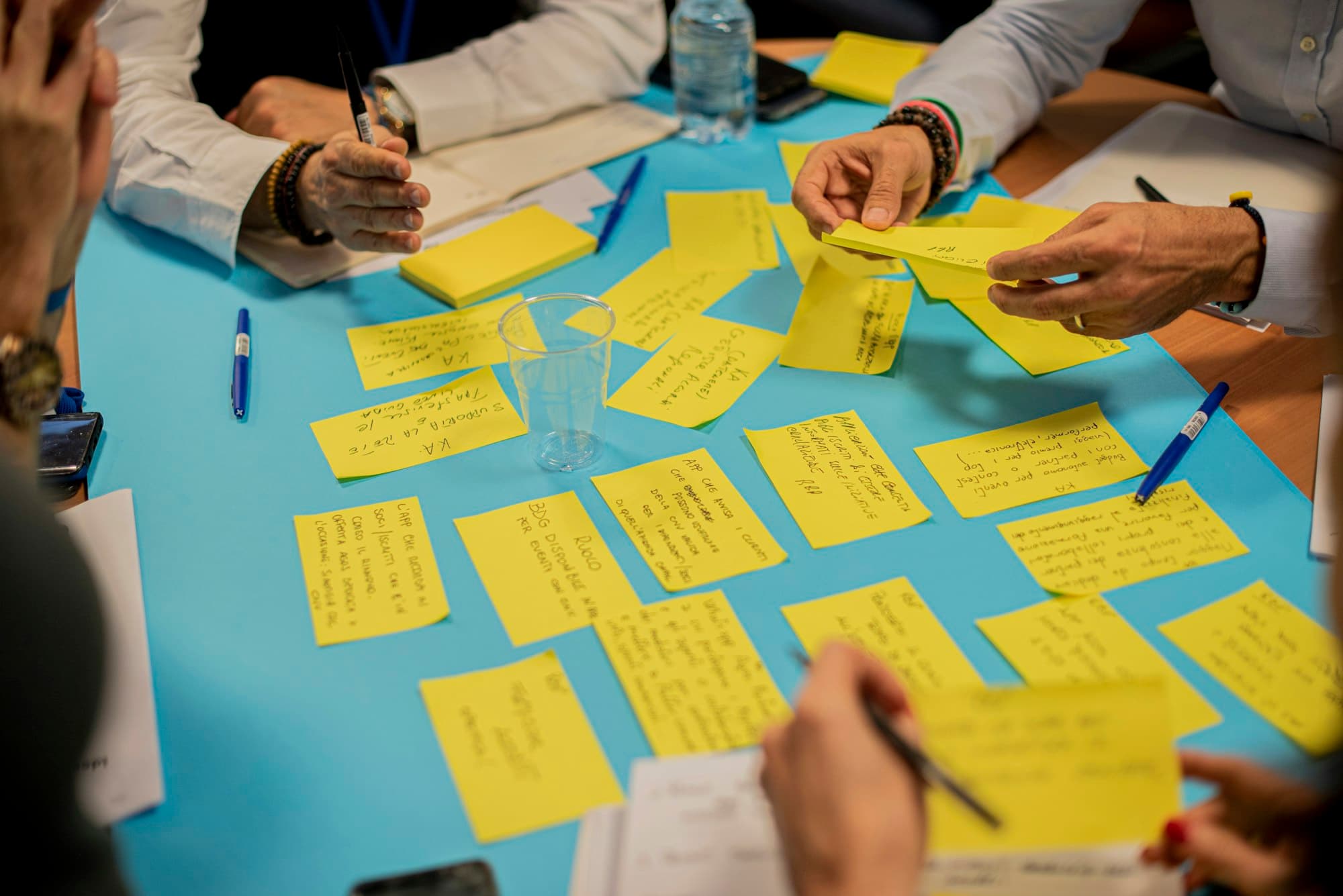 Iemand houdt gele plakbriefjes vast tijdens een werksessie